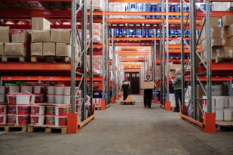 Warehouse workers moving inventory between shelving aisles