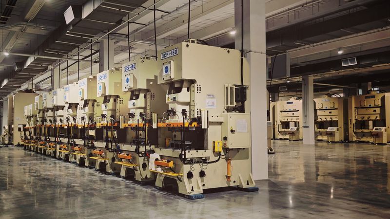 Row of industrial fabrication machines on a factory floor